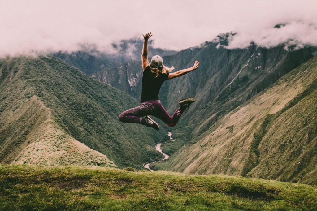 Woman jumping with joy over a canyon