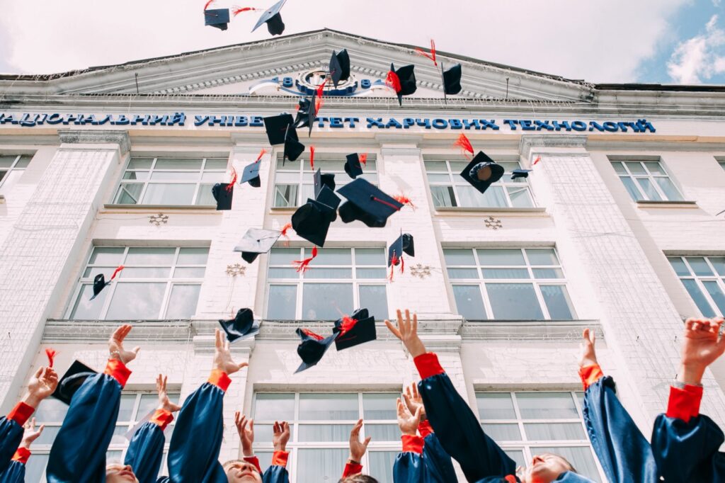 Students throwing graduation caps into the air